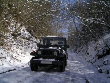 Samochód terenowy na leśnej drodze w trakcie zimy