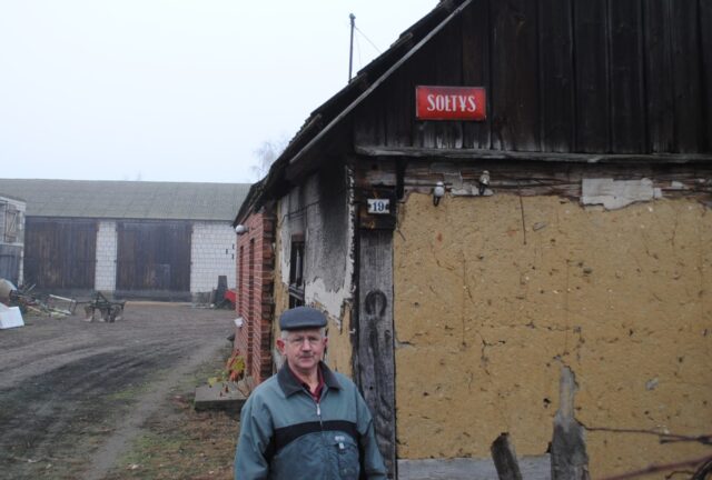Sołtys Erazm Walkowiak przy swoim dawnym domu, na którym wciąż wisi tabliczka zawieszona w latach 70′