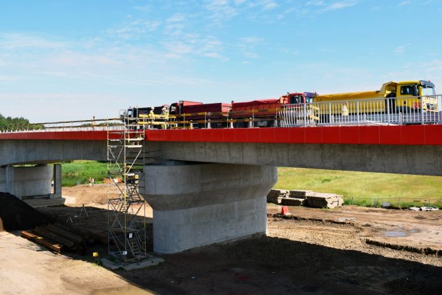 Ciężarówki, obciążone piaskiem wjeżdżają na nowy most w Rogalinku