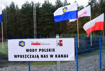 Baner na płocie oczyszczalni ścieków w Mosinie z napisem: Wody Polskie wpuszczają nas w kanał (Aquanet)