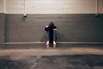 Ilustracja przedstawiająca osobę z problemami emocjonalnymi, zamyśloną i smutną, symbolizującą depresję i jej wpływ na zdrowie psychiczne.